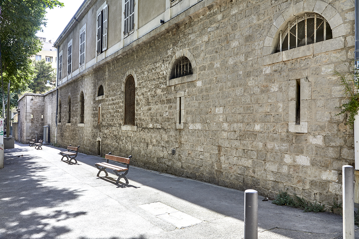 Segment ouest du mur de clôture crénelé sud formant façade extérieure du bâtiment d'entrée ouest.
