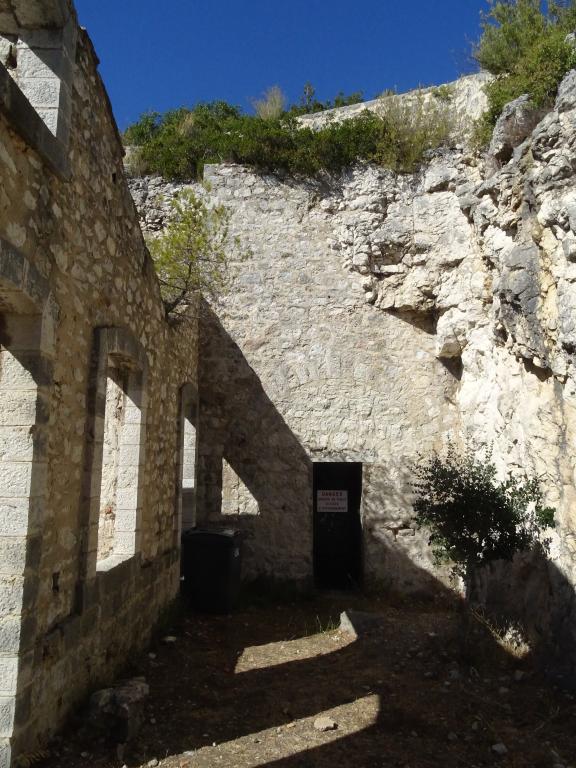 Mur-pignon est du casernement (a) et de son couloir d'isolement, et issue murée du souterrain-caverne.