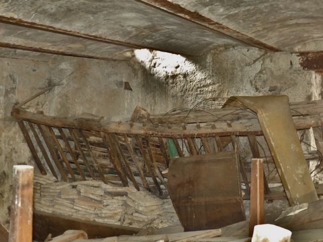 Etage de soubassement, étable. Mur est, mangeoire sur banquette maçonnée et râtelier surmonté d'une trappe d'abat-foin.