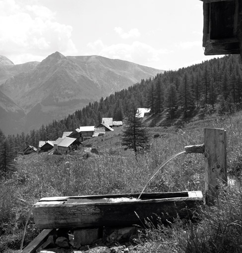 Chalets de Granon : La Caro. Vue de situation prise depuis Granon. Au premier plan, fontaine et abreuvoir en bois.