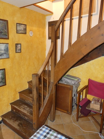 Rez-de-chaussée surélevé, logis. Escalier menant à l'étage.