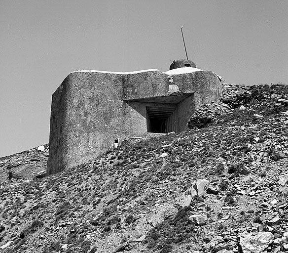 Ouvrage E. Bloc 1. Flanc droit. Sous la visière, le créneau de jumelage de mitrailleuses flanquant vers le point 2232. Au-dessus, la cloche de GFM..