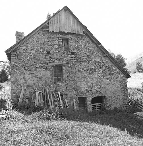 Façade sud-est. A noter la ligne de trous de boulins dont deux ont été transformés en fenêtre et le bardage du pignon à l'aplomb du toit.