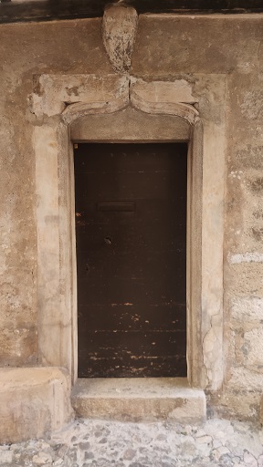 Maison (2022 AY 125). Porte du logis avec encadrement en pierre de taille calcaire avec linteau délardé en accolade et moulures. 