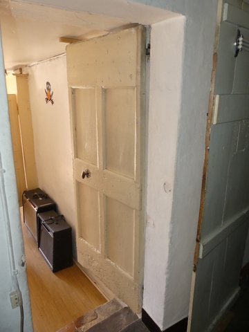 Rez-de-chaussée surélevé, cuisine. Mur sud, porte de la chambre sud-est.