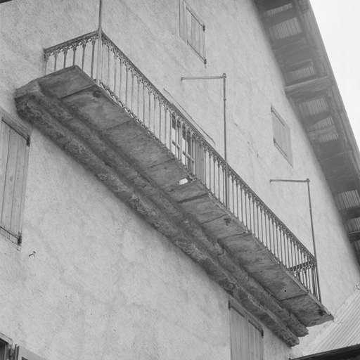 Balcon du pignon sud : lauzes portées par une double corniche en tuf, encastrées dans le mur.