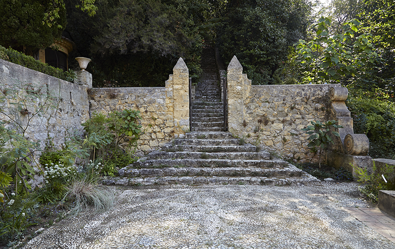 La calade de la cour du mandarinier et la porte ouvrant sur le bois.