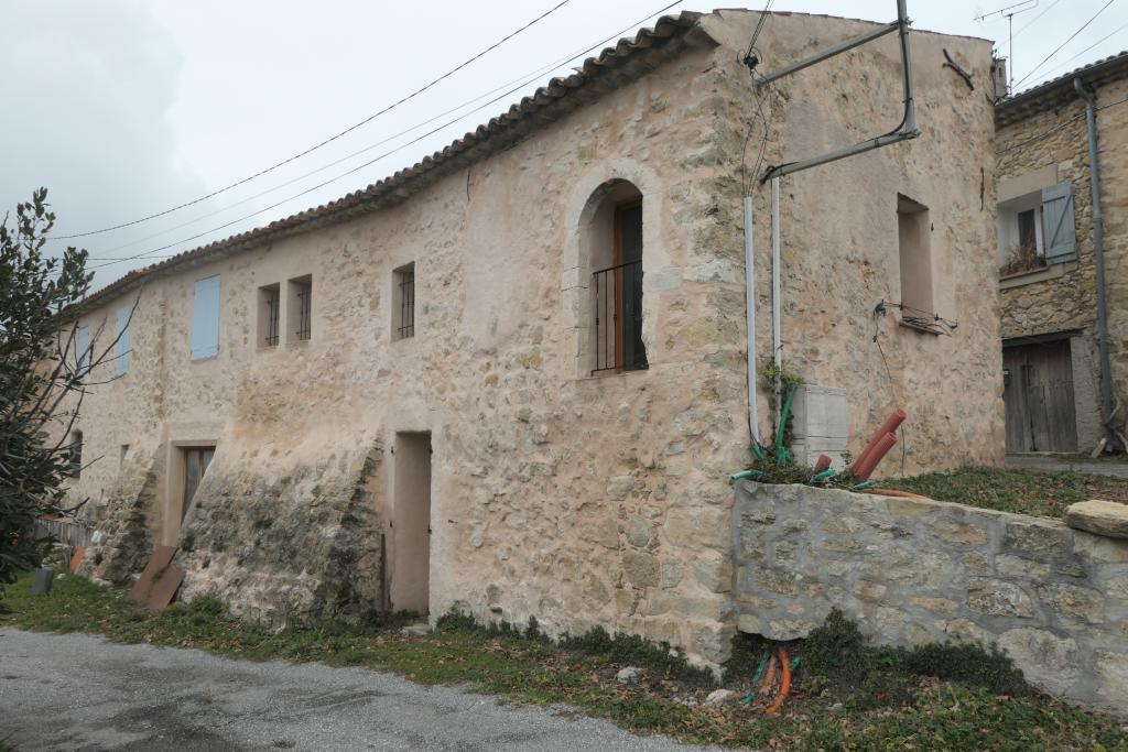 Ilot central, maison-étable orientale, porte haute à arc segmentaire du 18e siècle (parcelles 1001 et 1002 du cadastre de 1842).