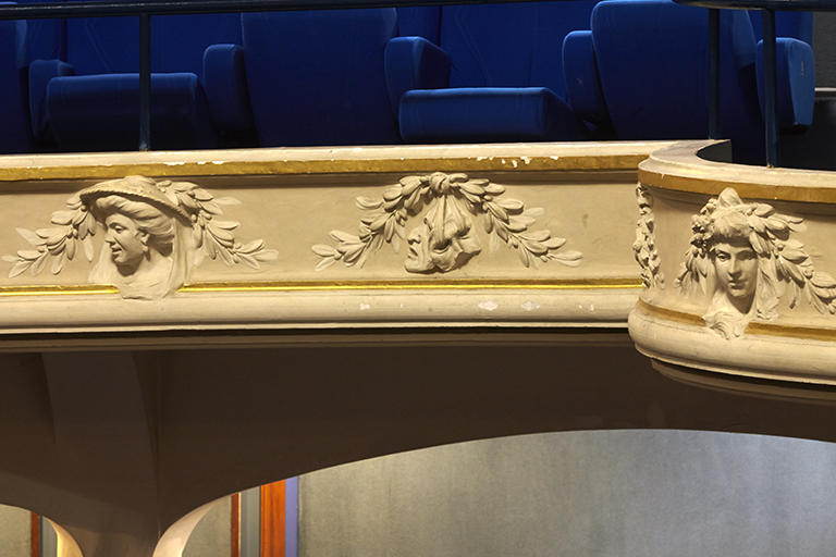 Théâtre. Premier balcon. Décor de visages et de masques de théâtre en haut-relief néo-18e siècle.