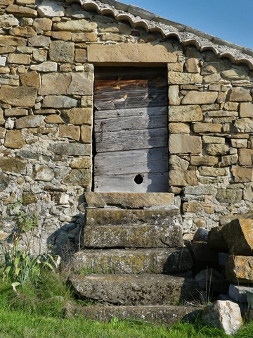 Dépendance nord. Pignon ouest, porte du fenil sud et escalier de distribution extérieur.