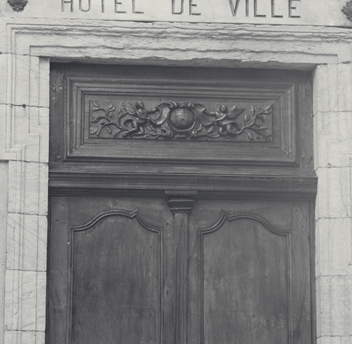 Façade antérieure est. Porte d'entrée. Détail de l'imposte sculptée aux armes de la ville.