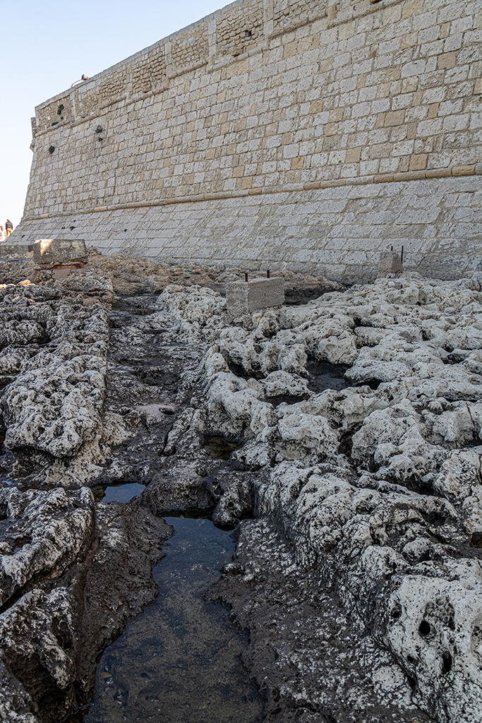 Elévation extérieure de la muraille du segment ouest du front sud, reconstruite en 1948. Au pied, tranchée de fondation dans le roc de la berme