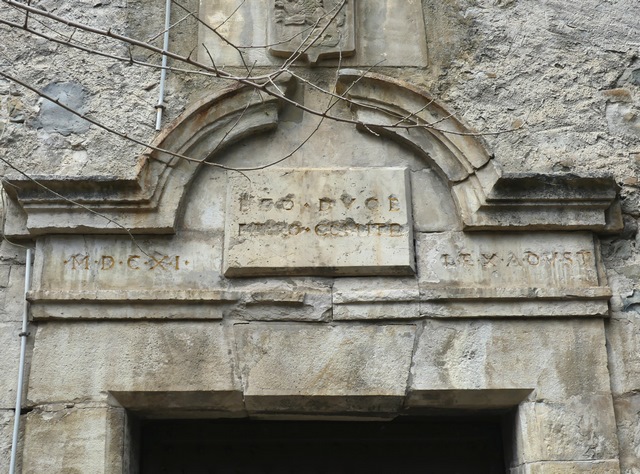 Escalier est. Elévation sud, premier niveau. Porte, détail du couvrement avec date portée (10 août 1611) et devise de la famille d'Yze.