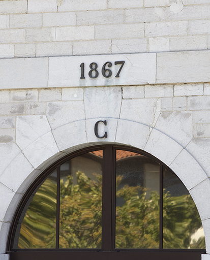 Bâtiment sud, détail de l'arcade millésimée en façade sur cour.