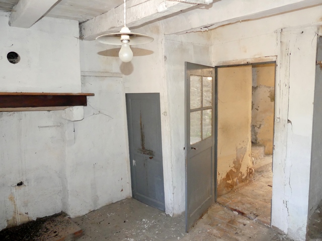 Rez-de-chaussée surélevé, cuisine. Partie sud-ouest, cheminée, placard du réduit sous l'escalier et porte du vestibule.