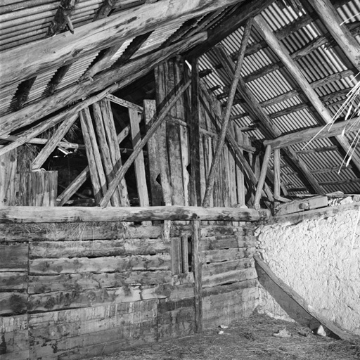 Dans la grange, la charpente et la cloison formant la mitoyenneté avec le chalet voisin.