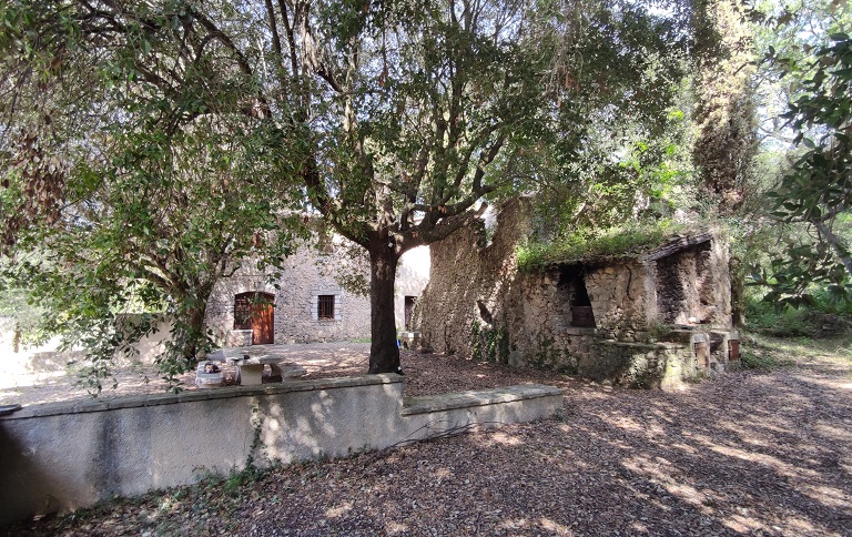 Vue d'ensemble prise du sud-est. À gauche, la maison reconstruite après 1926 ; à droite la ferme en ruine avec le four à pain au premier plan et la maison-bloc dans le prolongement.