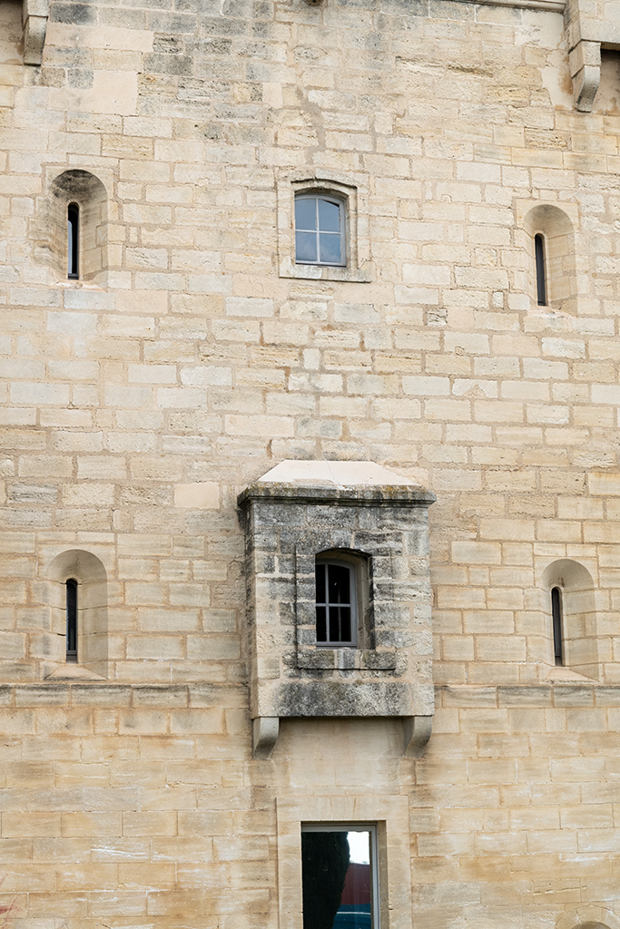 Tour Saint-Louis, détail de la face côté Rhône, bretèche au-dessus de l'ancienne porte remaniée, fenêtres et créneaux de fusillade ébrasés.
