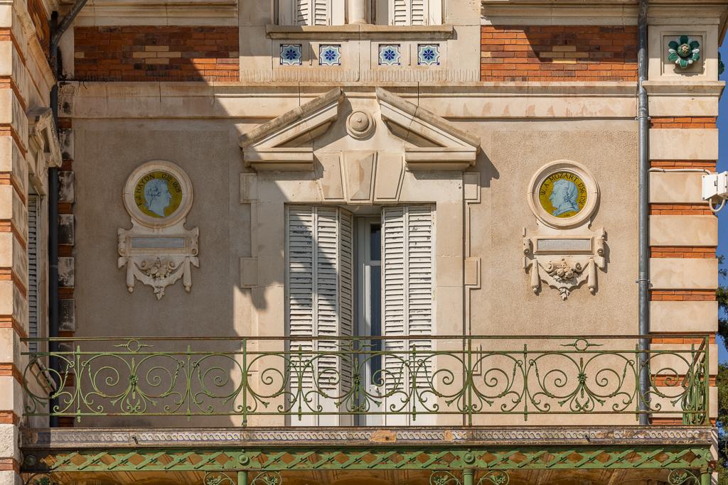 Façade sud : vue partielle, balcon et médaillons. 