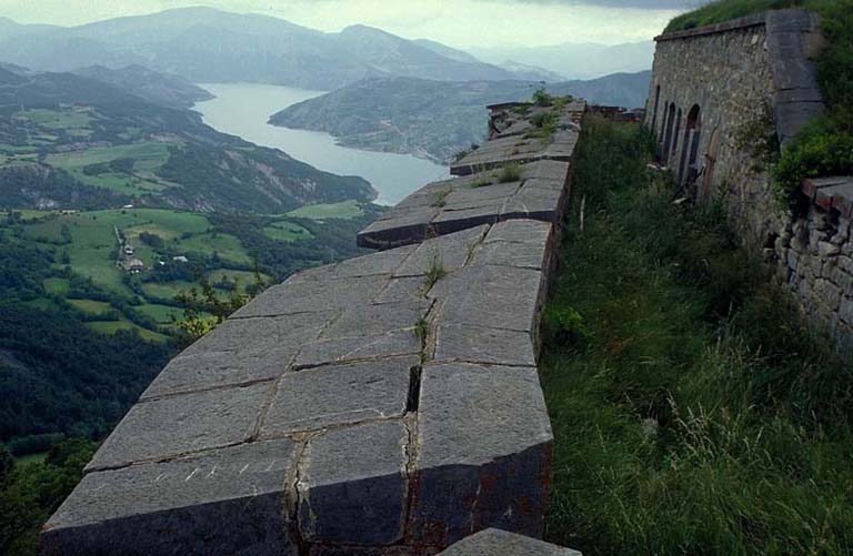 Vue d'enfilade de la face sud-ouest prise du bastion 2 vers le nord. A droite, façade des casemates D. Au fond, le lac de Serre-Ponçon.