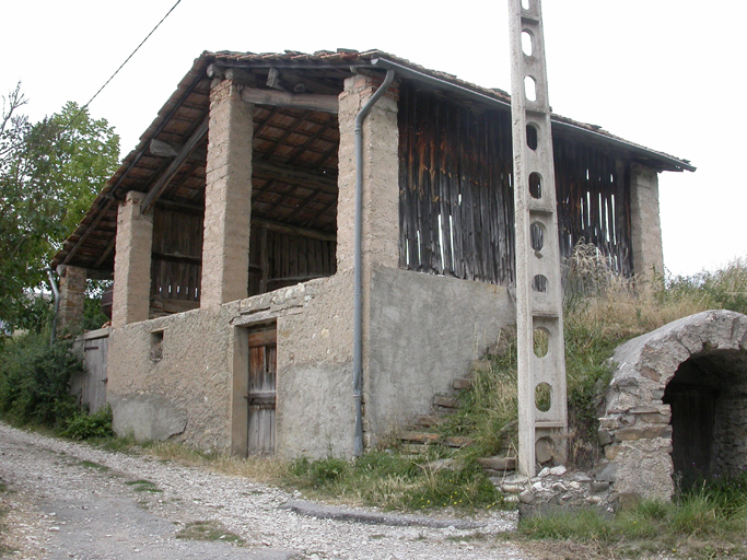 Toueste, parcelle WE 251 : hangar à 8 piliers sur un étage de soubassement en parpaings de béton artisanaux, avec cloisons en planches.