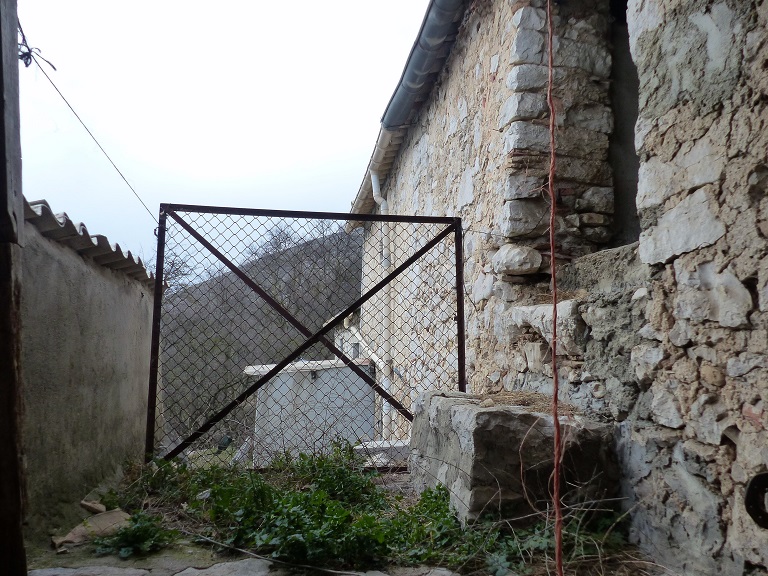 Bâtiment 1. Elévation sud, deuxième niveau. Repos de l'escalier extérieur et porte fenière.