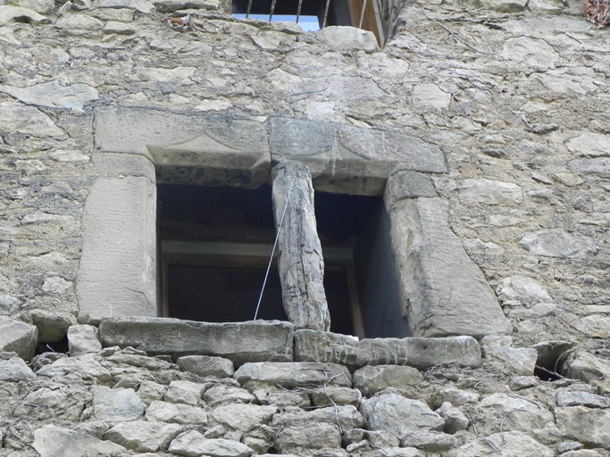 Parcelle D204. Fenêtre à meneau, avec double linteau à accolades surmontées d'une croix.