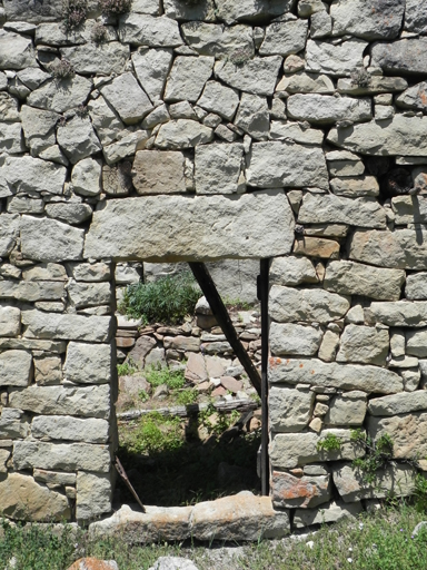 Les Raboulx. Porte d'étable en moellons équarris avec linteau monolithe ; arc de décharge maçonné.