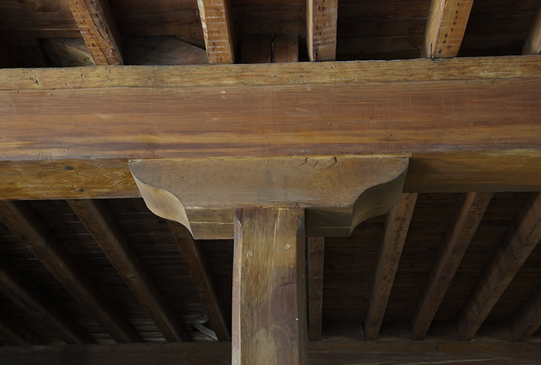 Détail du sabot de couronnement d'un pilier en bois du bâtiment nord.
