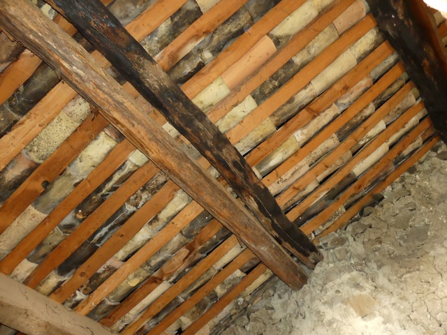 Charpente à pannes et couverture en tuiles creuses posées sur chevrons taillés en quartons.
