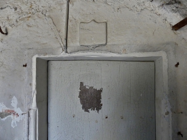 Partie ouest. Elévation ouest, premier niveau. Porte du logis, partie supérieure en plein cintre ultérieurement retaillée.