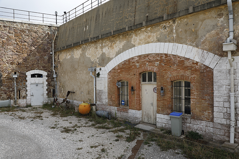 Détail de la façade du casernement casematé, travée de la casemate de gauche, angle rentrant de la cour et retour du revêtement, avec porte du magasin à poudres