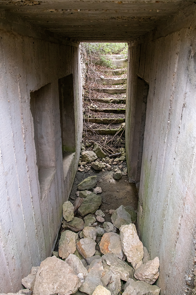 abri-soute enterré indépendant d'une cuve, à proximité de la cuve 2, double volée d'escalier d'accès et vestibule, vus du bas