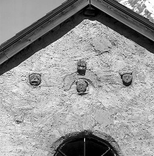 L'oculus du pignon ouest est surmonté de masques sculptés dans le tuf.