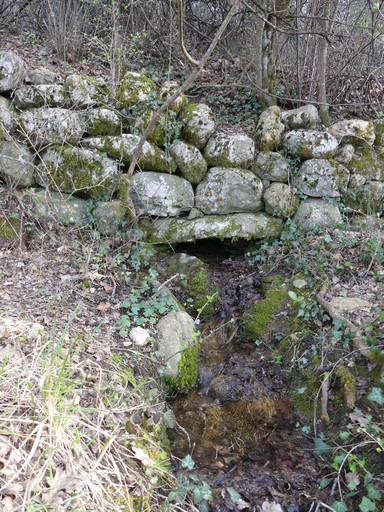 Source aménagée dans un mur de soutènement en pierre sèche, au quartier des Faysses.