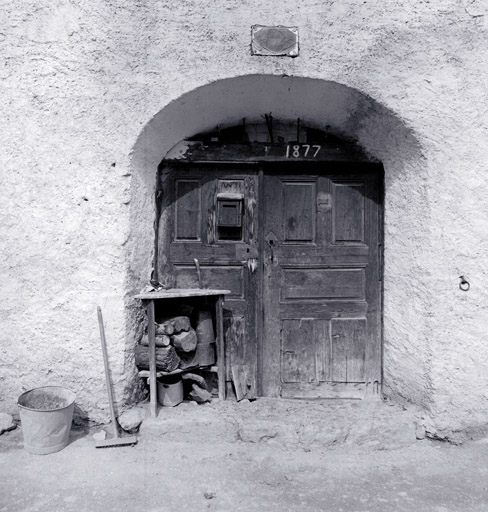 Façade antérieure nord. Porte d'entrée et ses vantaux. La date 1877 a été repeinte sur l'ancienne inscription.