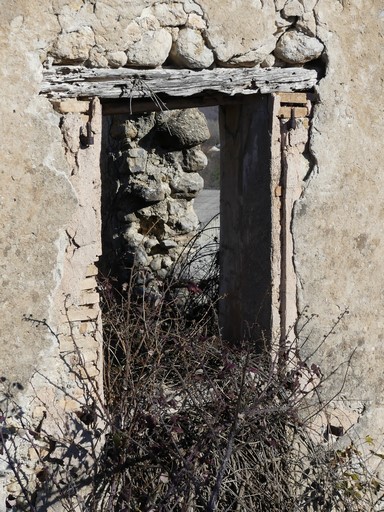 Fenêtre de logis saisonnier, avec encadrement en carreaux de terre cuite et inteau en bois, puis façonné au mortier de gypse. Bâtiment au quartier des Faysses (Ribiers).