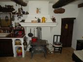 Détail d'un intérieur de logis avec cheminée adossée au mur d'une cuisine dans une maison à Jaussiers (Ubraye).