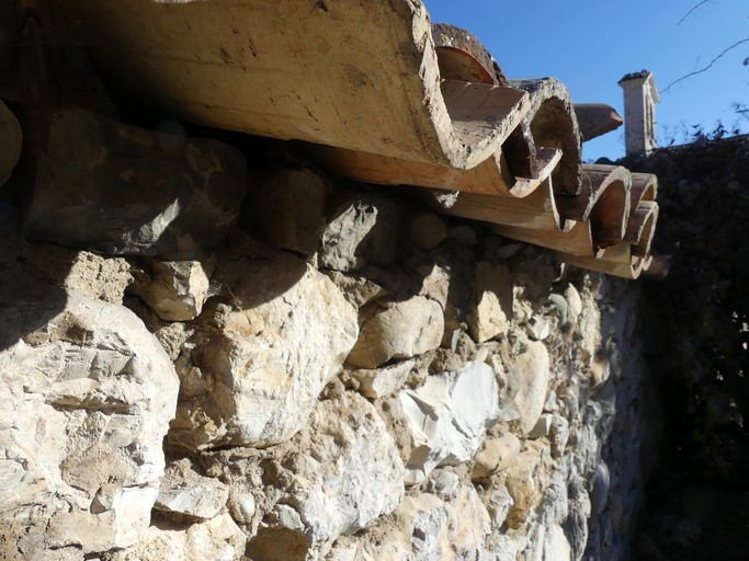 Avant-toit constitué du débord des tuiles de couverture. Bâtiment au village d'Antonaves.