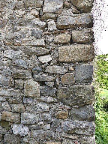 Chaîne d'angle en moellons équarris, entrepôt agricole au bourg.