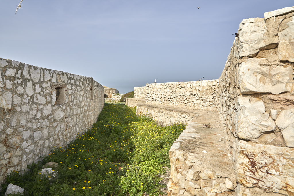 Partie centrale étranglée de l'aire intérieure entre les murs parapets de l'enceinte des fronts sud (à gauche) et nord (à droite)