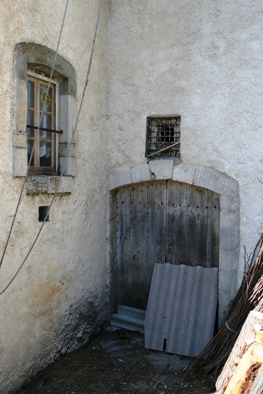 Façade est. Entrée d'un espace agricole à l'étage de soubassement dont l'encadrement en pierre de taille est en partie masqué par une adjonction. 