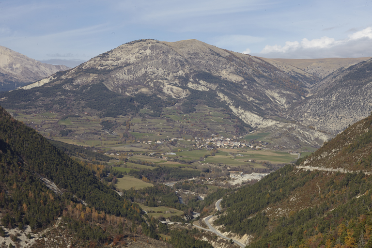 Vue d'ensemble de la plaine haut-thoramaise depuis la route départementale 908 menant à l'écart de la Colle-Saint-Michel. Au fond, la montagne de Chamatte.
