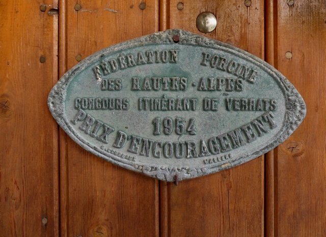 Bâtiment de la grange-étable. Elévation sud, premier niveau. Porte de l'étable ouest, plaque de prix agricole.