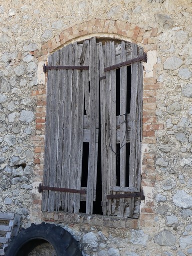 Baie fenière avec encadrement en arc segmentaire en brique pleine. Ferme du Prieuré (Ribiers).