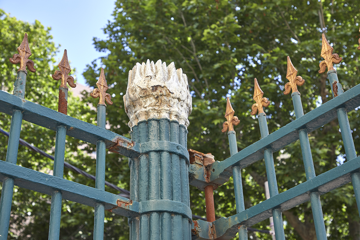 Détail de la grille d'entrée, pilier de fonte en fasce de lances.