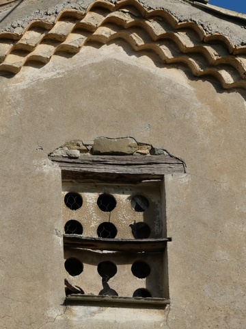 Bâtiment du pigeonnier. Pignon sud, troisième niveau. Baie du pigeonnier avec grille d'envol en mortier de gypse.