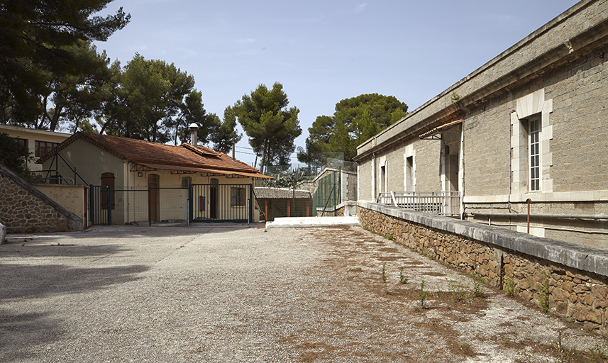 Cour du fort, bâtiments XXe s, façade et fossé d'isolement de la caserne, passerelle d'accès.