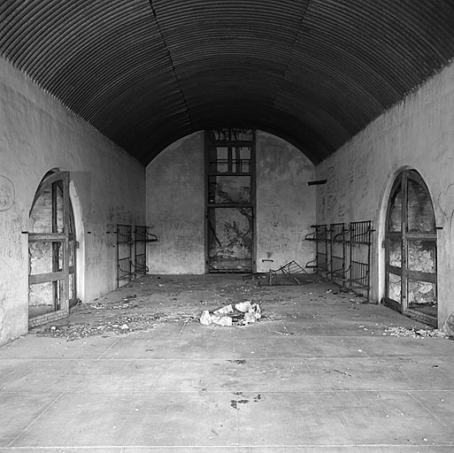 Caserne A. Casemate du premier étage. Vue intérieure. En haut, doublage en tôle de la voûte. Au mur, vestiges de lits de forteresse modèle 1874.