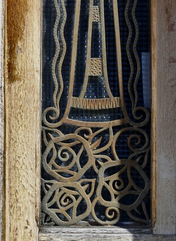 Pignon nord, premier niveau. Porte du logis, détail de la grille en fonte moulée.